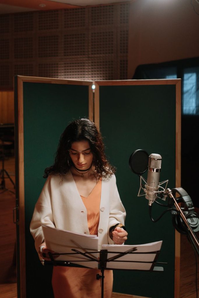 pexels photo 7086305 A female singer in a recording studio with microphone and music stand.