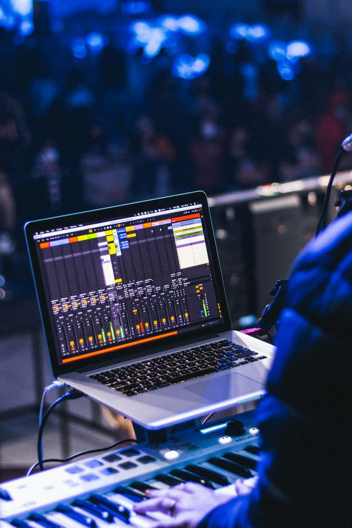 services-03 Musician using laptop for mixing during live performance in concert setting